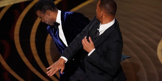 Will Smith raakt presentator Chris Rock op het podium terwijl hij zijn prijs voor beste documentaire uitreikt tijdens de Academy Awards.