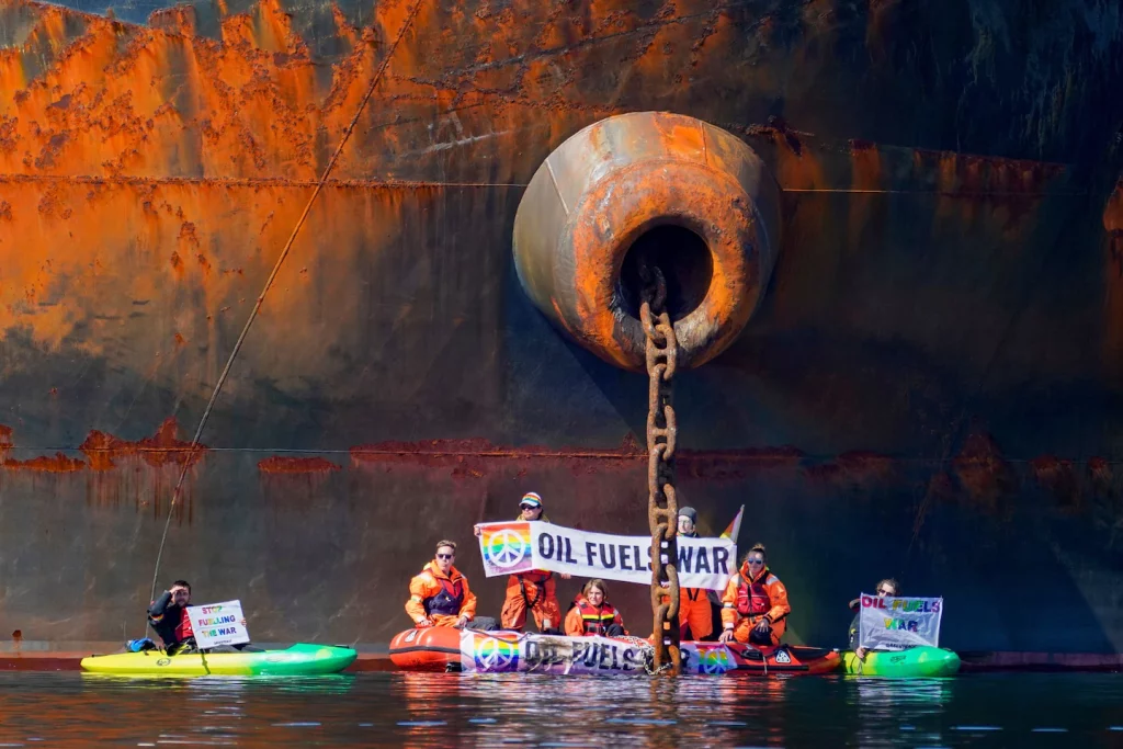 Demonstranten van Greenpeace Oekraïne binden een kajak vast aan een Russische olietanker