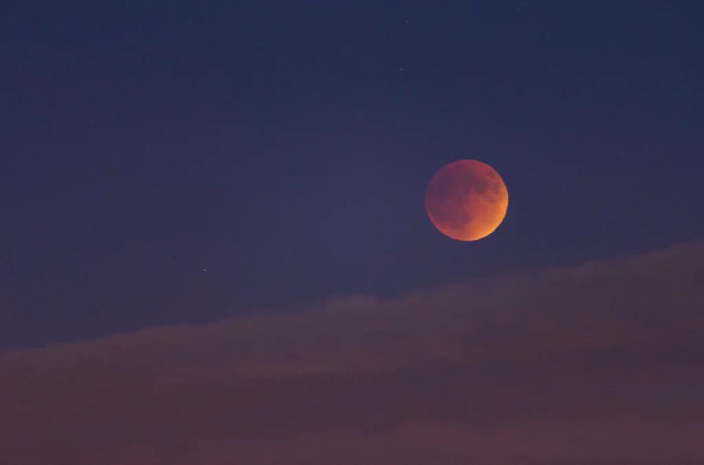 De maan kleurt rood tijdens de totale maansverduistering op zondagnacht