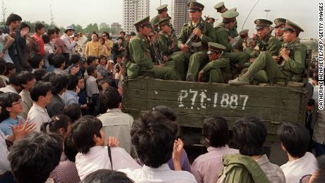 Pro-democratische demonstranten blokkeren een vrachtwagen vol Chinese soldaten op weg naar het Tiananmen-plein, 20 mei 1989. 
