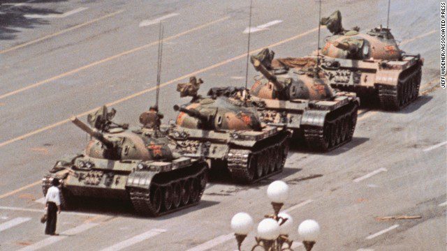 Een eenzame man met boodschappentassen stopt tijdelijk de opmars van Chinese tanks na het bloedige optreden tegen demonstranten, Peking, 5 juni 1989.