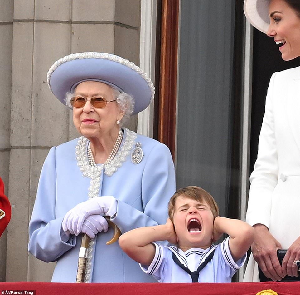 De koningin lacht als prins Louis zijn oren bedekt terwijl hij vanmiddag over Buckingham Palace in Londen vliegt