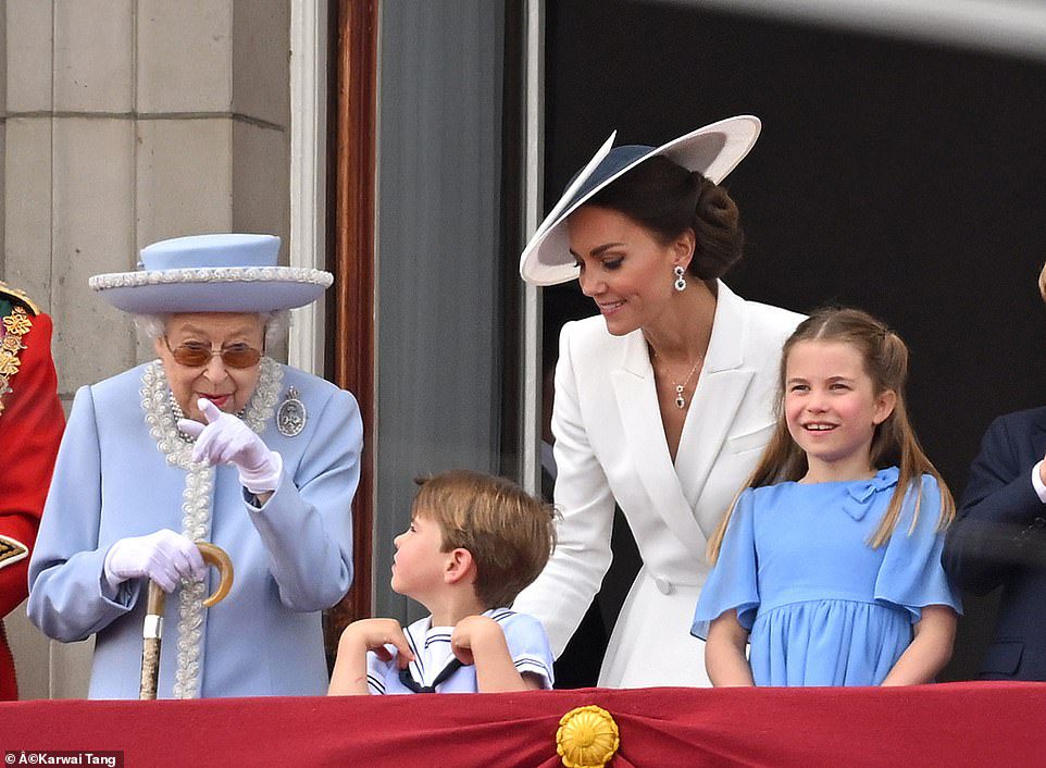 Koningin Elizabeth II wijst erop terwijl ze vanmiddag naast prins Louis op het balkon van Buckingham Palace in Londen stond