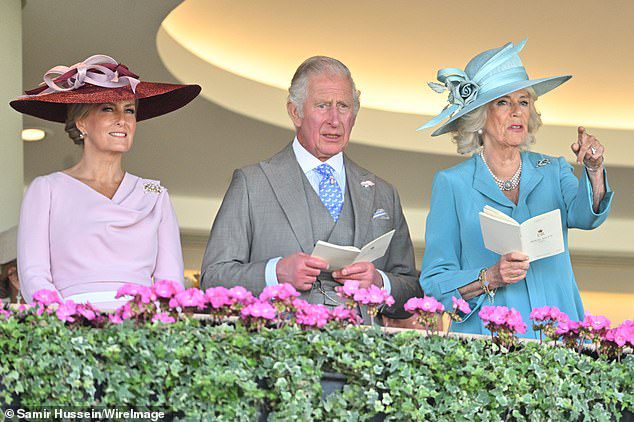 Ondertussen wees Camilla over het circuit terwijl ze poseerde naast prins Charles en schoonzus Sophie Wessex.