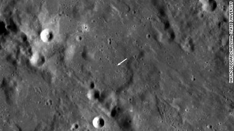 De nieuwe krater is kleiner dan de andere krater en niet zichtbaar in deze weergave, maar de locatie wordt aangegeven door de witte pijl. 