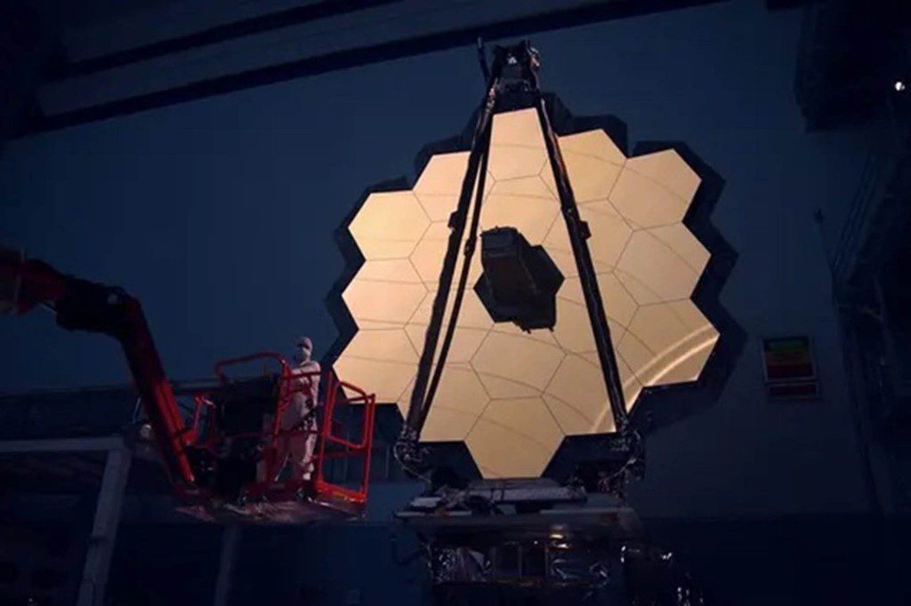 De hoofdspiegel van de James Webb Space Telescope wordt verlicht in de donkere kamer
