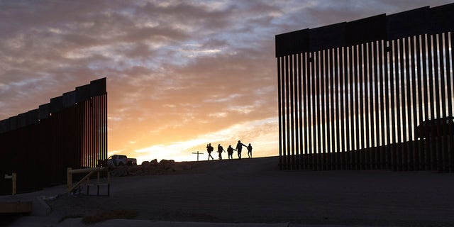 BESTAND - Immigrantenfamilies uit Brazilië passeren een gat in de grensmuur om de Verenigde Staten te bereiken nadat ze van Mexico naar Yuma, Arizona zijn overgestoken om asiel aan te vragen.