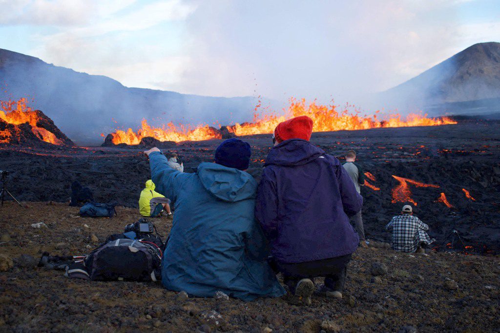 Toeschouwers verwonderen zich over de uitbarsting en stroom van lava in Grindavik, IJsland op 3 augustus 2022.