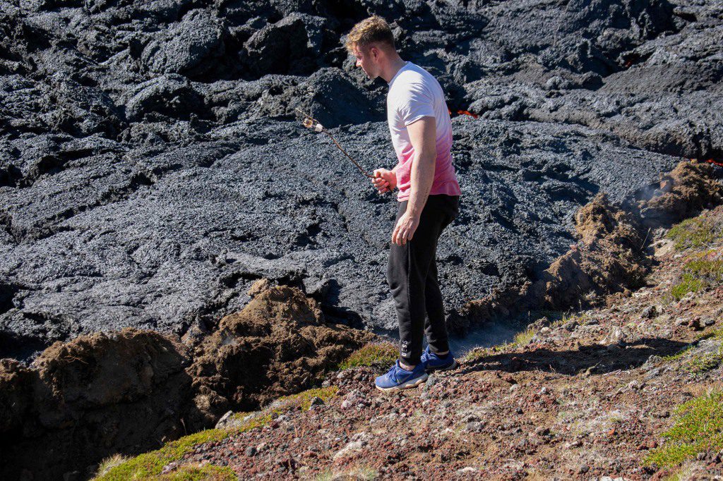 Een man verwarmt voedsel op een stok in een scène van een pas uitgebarsten vulkaan in de Miradaler-vallei, nabij de berg Vagradalsvilla, IJsland op 4 augustus 2022.