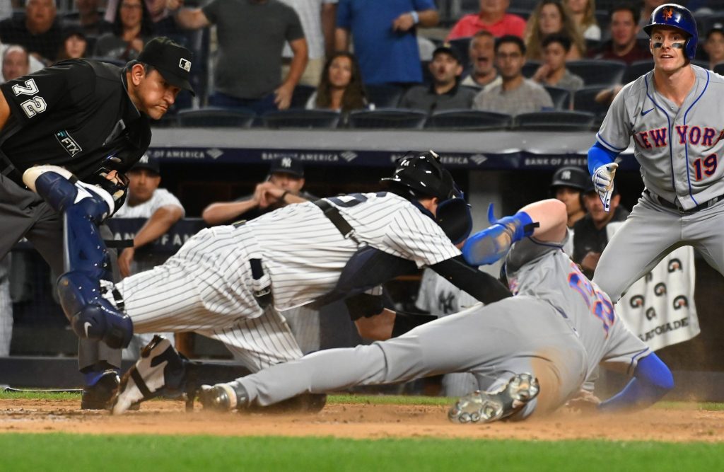 Mets-derde speler Brett Patty (22) wordt thuis getikt in een poging te scoren op een nummer van Starling Marty (6) tijdens de vijfde inning van een wedstrijd tegen de Yankees op dinsdag 23 augustus 2022 in het Yankee Stadium.