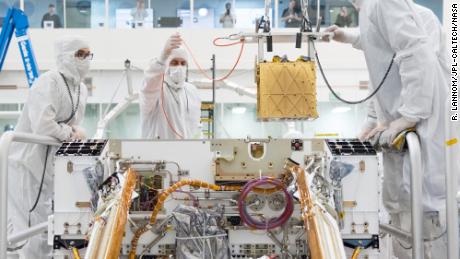 Leden van NASA's Mars 2020-project installeren het Mars Oxygen Resource Utilization Experiment (MOXIE) in het chassis van de Persevering Rover. 