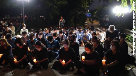 Een kleine menigte houdt op 11 augustus een wake bij kaarslicht in Seoel om de dood van een gezin te herdenken nadat hun huis op 8 augustus onder water kwam te staan.