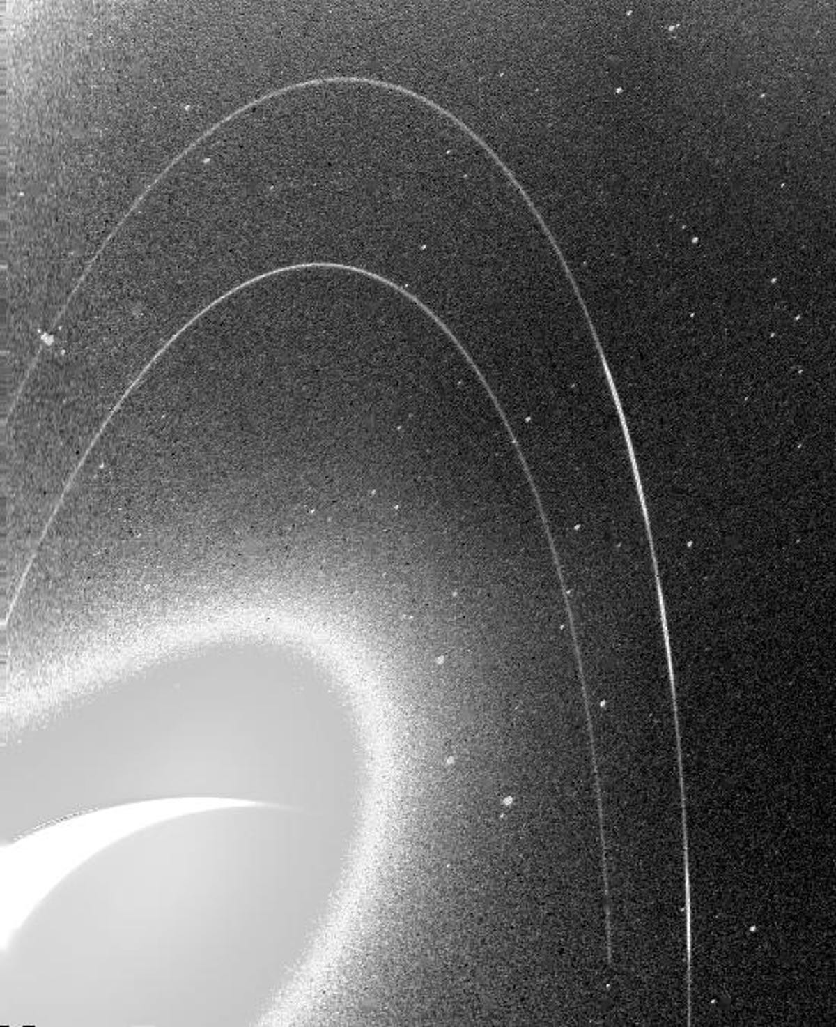 De korrelige zwart-witafbeelding toont de vage ringen van Neptunus.