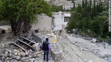 Een lokale bewoner staat naast zijn verwoeste huis in juni nadat een explosie van een gletsjermeer catastrofale overstromingen veroorzaakte in het dorp Hassanabad in het noorden van Pakistan. 
