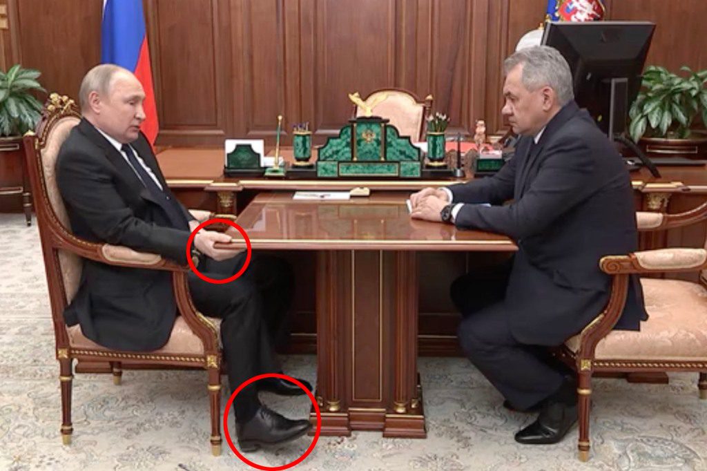 Vladimir Poetin zit aan tafel tijdens een recente bijeenkomst, wat heeft geleid tot speculaties over zijn gezondheid.