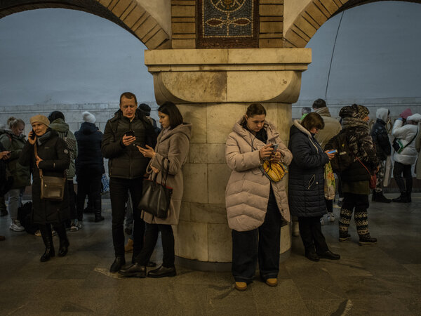 People stand in a Kyiv metro station on Monday to take shelter during strikes on Ukraine on Monday.