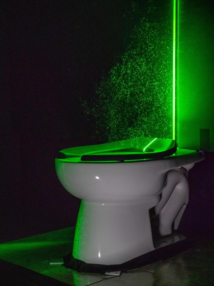 The powerful green laser helps visualize the toilet's aerosol plumes 